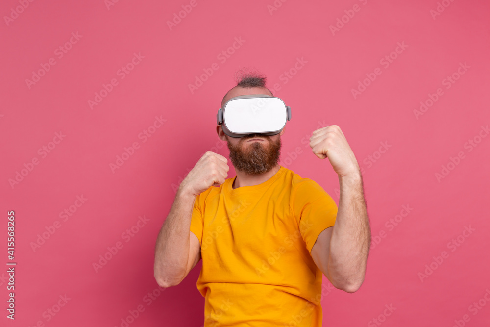 Handsome bearded man in vr glasses playing fight games studio background Handsome bearded man in vr glasses playing fight games studio background