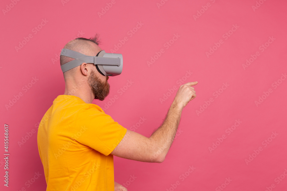 Handsome casual wear men in vr glasses side view pointing to the left text space Handsome casual wear men in vr glasses side view pointing to the left text space