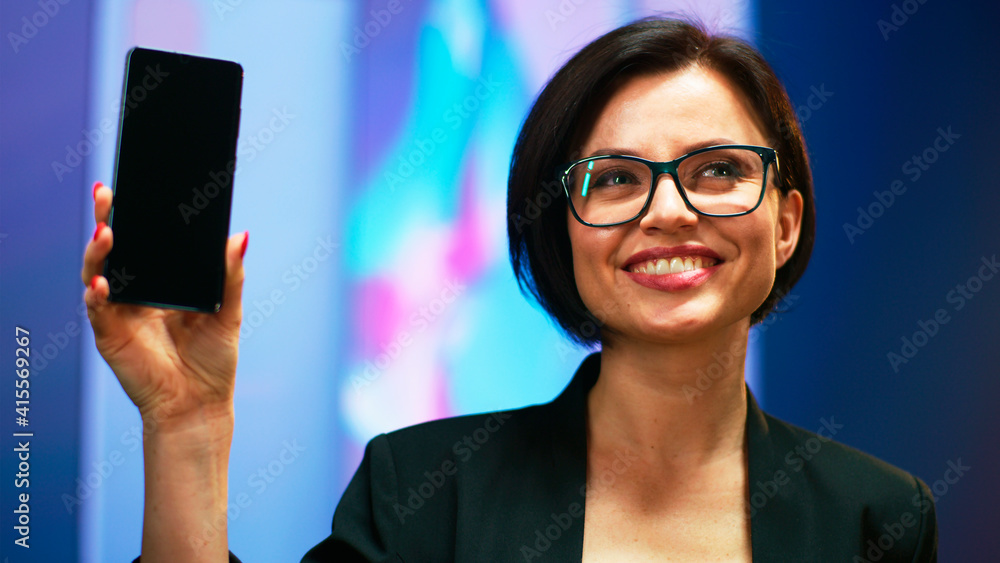 Cheerful woman demonstrating smartphone during presentation Cheerful woman demonstrating smartphone during presentation