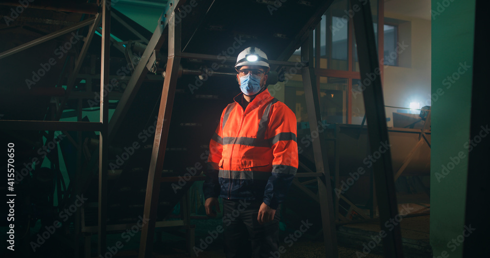 Factory worker in mask looking at camera Factory worker in mask looking at camera