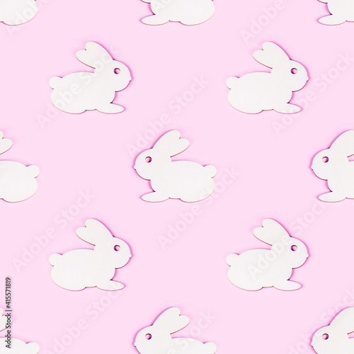 Funny wooden Easter Bunny seamless pattern on light pink background. © KatMoy