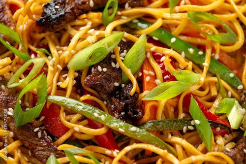 Stir fry noodles with beef and vegetable in white bowl. asian style food photo