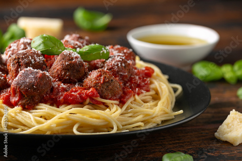 Vegetarian spaghetti with meat free, vegan meatballs in rich tomato sauce, grated cheese and basil leaves