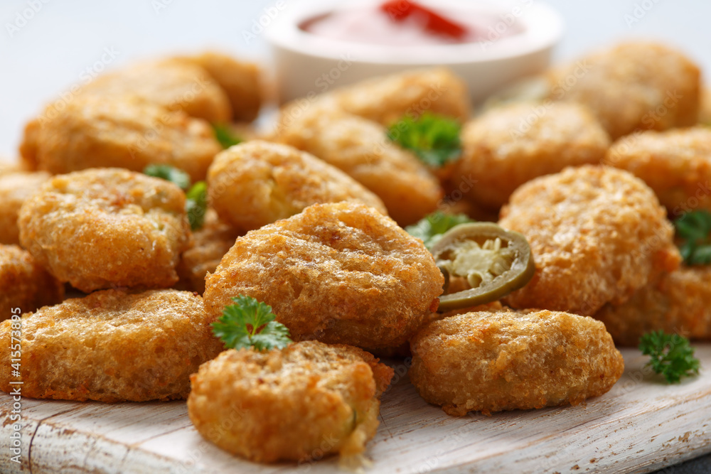 Crispy Jalapeno Popper with creamy cheese battered on white wooden board Crispy Jalapeno Popper with creamy cheese battered on white wooden board