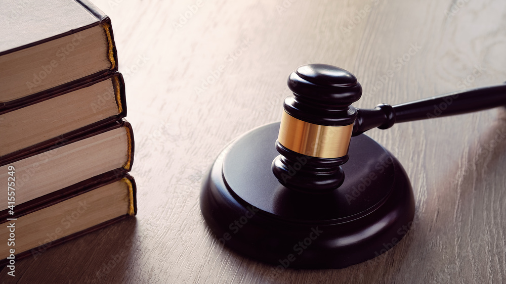 Old white phone and law hammer on wooden table with long shadows. Concept of legal advice, consultation, counseling over the phone. Old white phone and law hammer on wooden table with long shadows. Concept of legal advice, consultation, counseling over the phone.