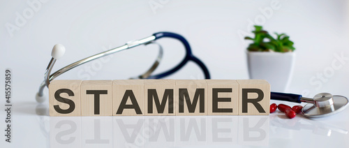 stammer the word is written on the wooden cubes and sthetoscope and piils . Medical concept