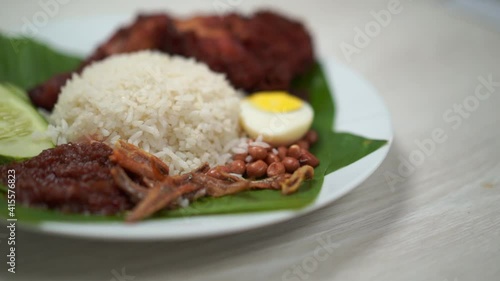 Nasi Lemak dish with chicken drum stick in slow motion