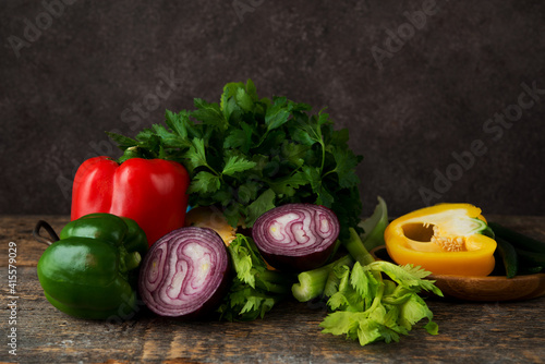 Fresh organic vegetables and herbs on a rustic wooden background
