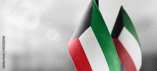 Small national flags of the Kuwait on a light blurry background