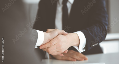 Wallpaper Mural Unknown businessman shaking hands with his colleague or partner above the glass desk in modern office, close-up. Business people group at meeting Torontodigital.ca