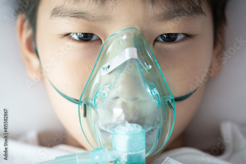 Young asian boy with face oygen mask photo