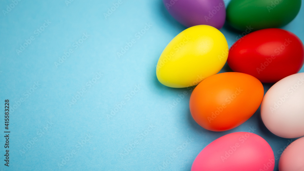 Flat lay set of decorated hand painted chaotically scattered colorful eggs on blue background. Happy Easter concept composition. Image with copy free space for text message Flat lay set of decorated hand painted chaotically scattered colorful eggs on blue background. Happy Easter concept composition. Image with copy free space for text message