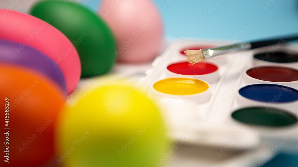 Flat lay set of decorated hand painted chaotically scattered colorful eggs on blue background. Preparing for spring holiday. Happy Easter concept composition. Image with copy free space