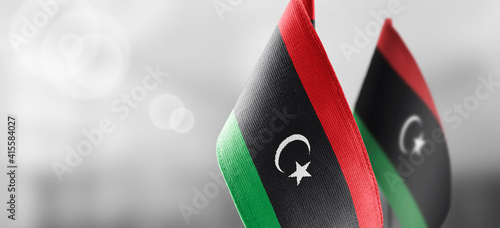 Small national flags of the Libya on a light blurry background
