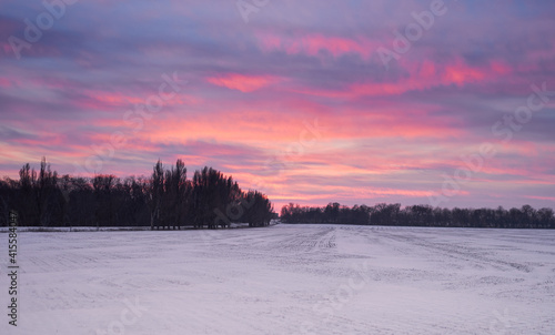 a field covered with snow at sunset