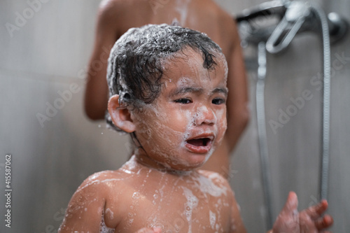 Fotografi a baby crying with a face full of soap lather in the bathroom