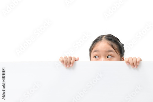 Photos Young girl with beautiful eyes peeking over white corrugated plastic board,