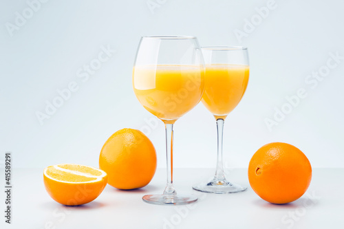 Two Glasses Of Orange Juice And Fruits On Gray Background. Natural Raw Food Concept.