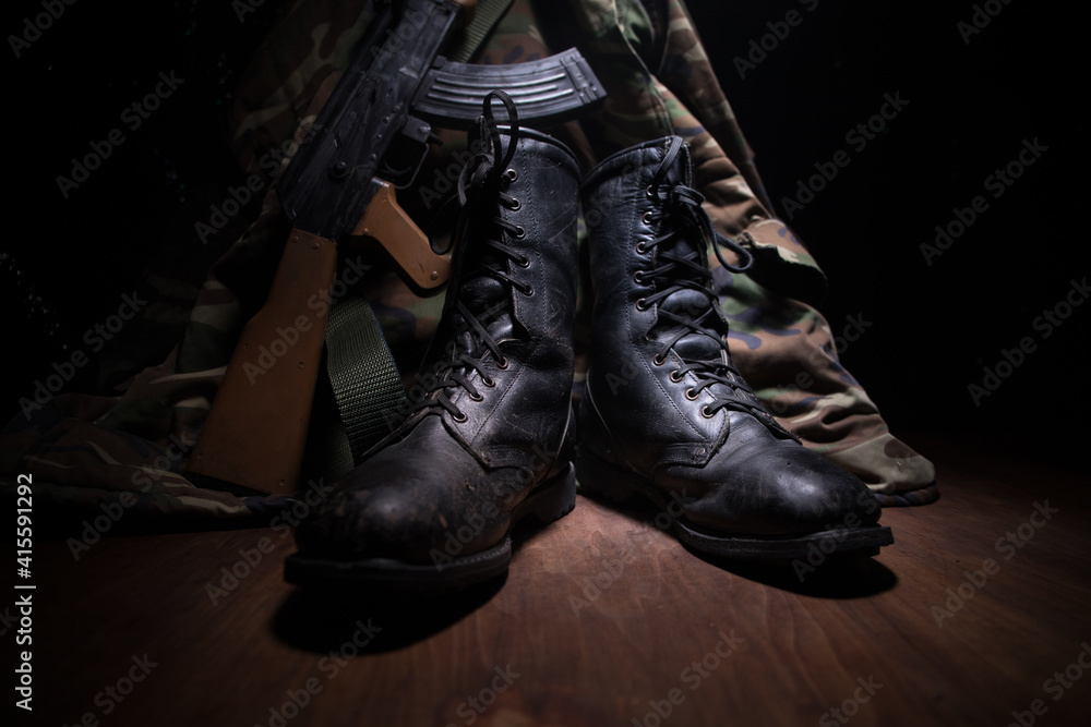 War concept. Old military shoe in a dark toned foggy background. Creative concept of conflict between countries, military aggression.