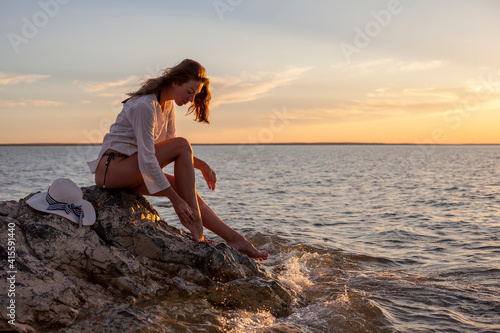 Beautiful woman enjoying sunset on the beach. © Lord_Ghost