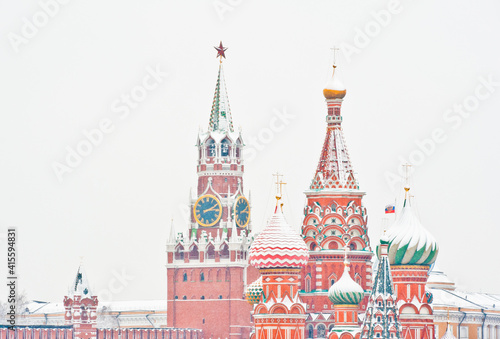 Spasskaya Tower of Moscow Kremlin and the Cathedral of Vasily the Blessed (Saint Basil's Cathedral) on Red Square. Winter day, heavy snow. Moscow. Russia