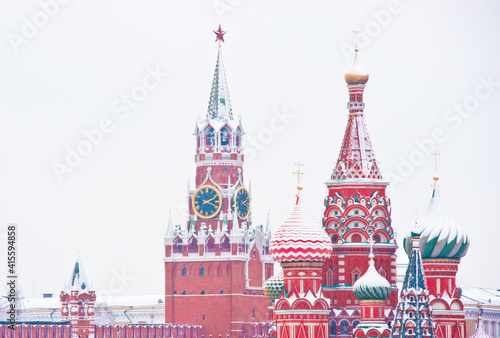 Spasskaya Tower of Moscow Kremlin and the Cathedral of Vasily the Blessed (Saint Basil's Cathedral) on Red Square. Winter day, heavy snow. Moscow. Russia