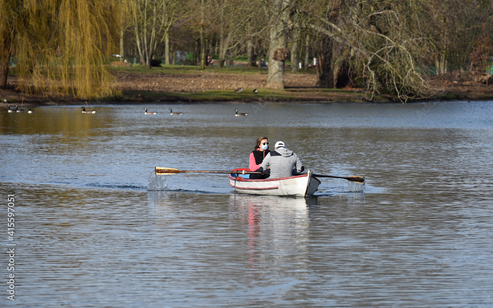 Fototapeta premium Mature couple wearing anti-covid face mask during a rawboat trip on the lake Daumesnil in the Bois de vincennes, Paris, FRANCE. 