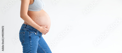 Close-up on the belly of a pregnant woman on a white background in the form of a banner. Treatment and prevention of diseases of pregnant women and newborns.