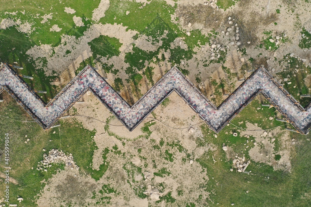Fototapeta premium Aerial top view abstract view of the park ground on the folding promenade