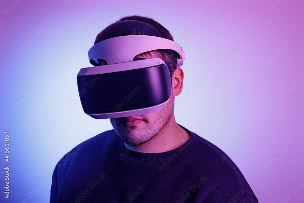 Person looks into virtual reality glasses on an isolated colored background Person looks into virtual reality glasses on an isolated colored background