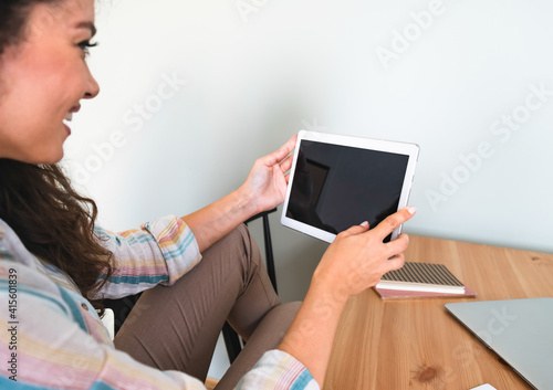 Smiling business woman holding digital tablet and talking on video chat. Beautiful young businesswoman have online meeting on black screen tablet. Woman working from home