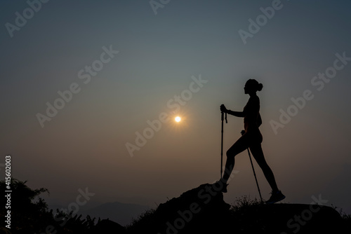 Silhouette Slim Girl of hikers walking in mountains. Woman hiker on a top peak mountain. Life Balance Woman Exercise. Girl adventure fit trekking and happy