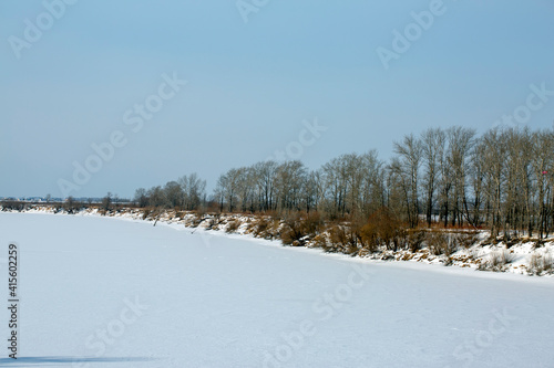 Winter snowy river landscape. Frozen ice on the river