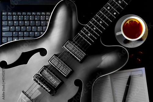 Acoustic guitar and notebook with diary online guitar lessons at home.