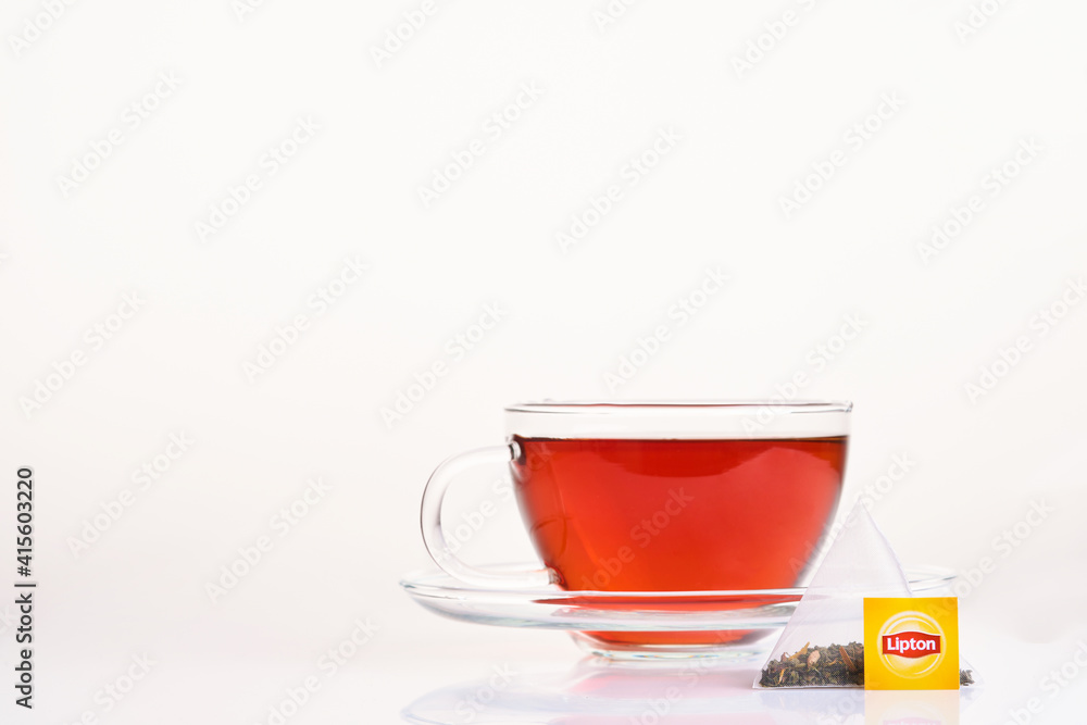 Fotka „MOGILEV, BELARUS - DECEMBER 15 2020: Lipton yellow label tea bag in  brown glass cup on isolated on a white background. Lipton is a British  brand of tea owned by Unilever