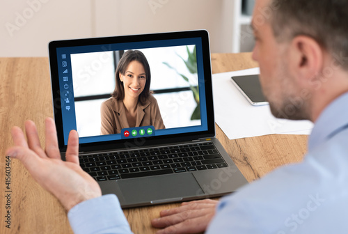 Male entrepereneur using laptop computer in office for online business meeting