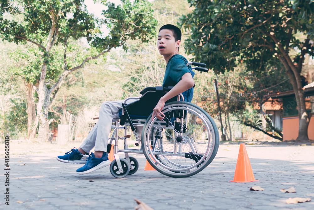 Special need child practicing wheelchair by parents, Skill of occupational development with pushing wheel chair, Lifestyle Cycle in the education age of disabled children, Happy disabled kid concept.