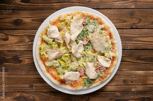 Caesar pizza with chicken breast, lettuce, cherry tomatoes and Parmesan cheese.