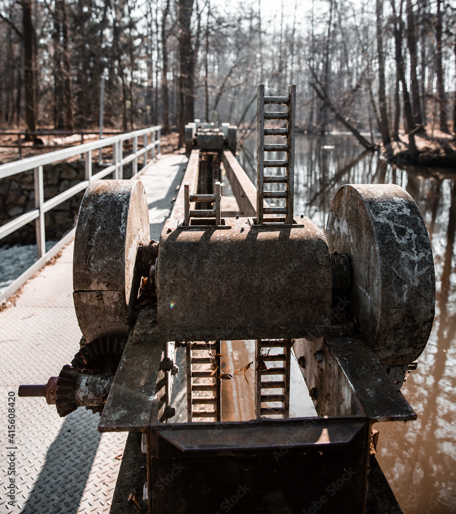Fototapeta premium water flowing over old broken weir on a river, landscape