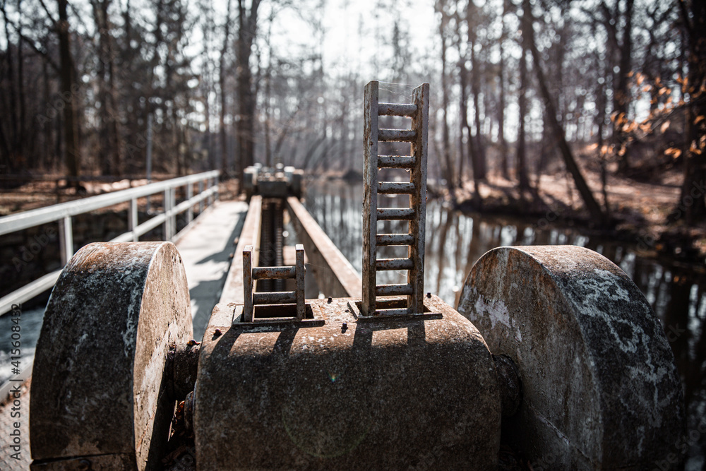 Fototapeta premium water flowing over old broken weir on a river, landscape
