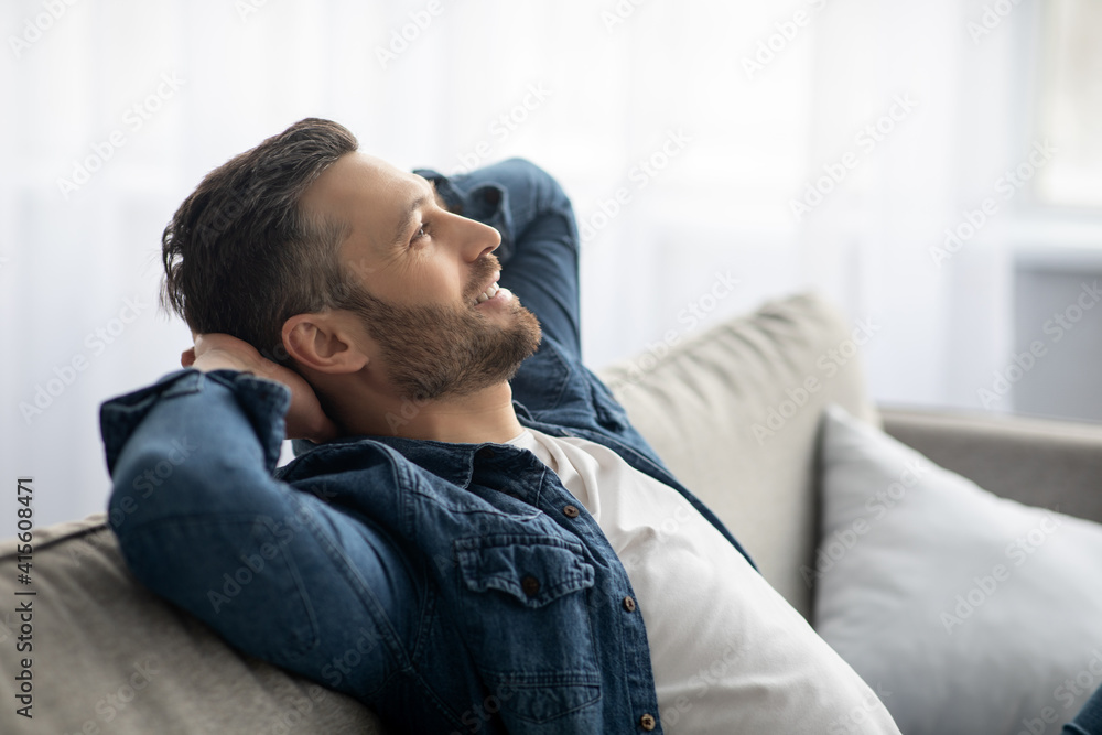 Handsome middle-aged man relaxing on sofa at home Handsome middle-aged man relaxing on sofa at home