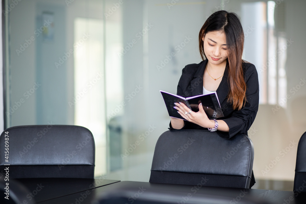 Portrait of asian young business woman sitting in office with notebook Portrait of asian young business woman sitting in office with notebook