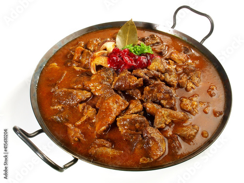 Wild Game Meat Ragout in a Pan with Cranberries isolated on white Background