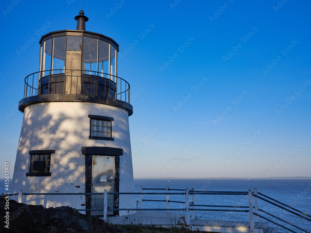 Owl's Head Lighthouse in late afternoon light overlooking the ocean on the Maine Coast