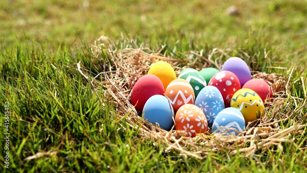 Happy Easter Day. Easter eggs on green grass background, Dolly shot. Camera moving through colorful easter eggs in nest on fresh green grass in morning. Happy Easter Day. Easter eggs on green grass background, Dolly shot. Camera moving through colorful easter eggs in nest on fresh green grass in morning.