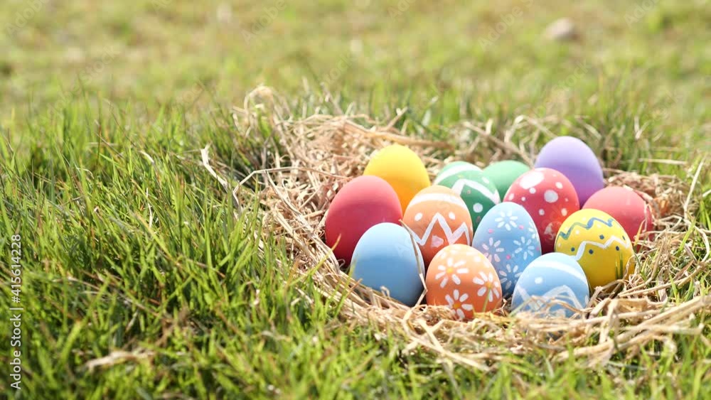 Happy Easter Day. Easter eggs on green grass background, Dolly shot. Camera moving through colorful easter eggs in nest on fresh green grass in morning. Happy Easter Day. Easter eggs on green grass background, Dolly shot. Camera moving through colorful easter eggs in nest on fresh green grass in morning.