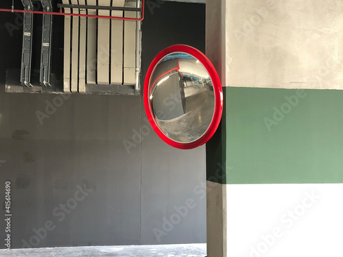 Traffic mirror on the wall at intersection or curve of road, safety and security concept, close up
