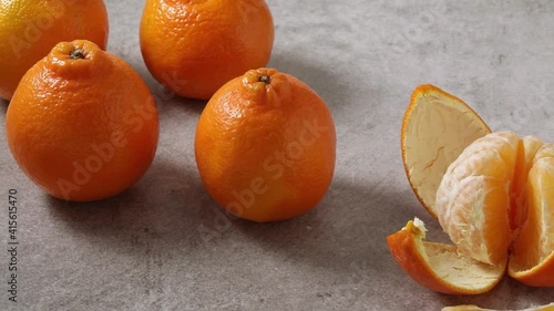 Fresh tangelos and a peeled one close up