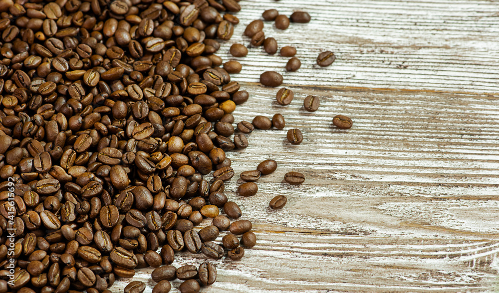 Grains of coffee on a wooden background.