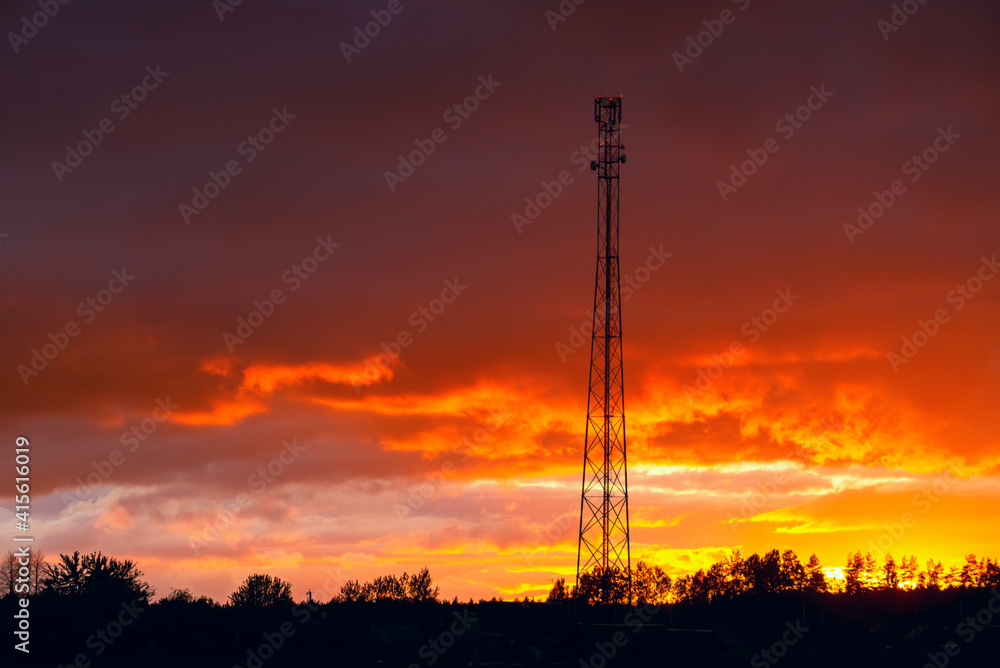 Telecommunication tower against the beautiful sunset sky, cell antenna, transmitter. Telecom TV radio cellular mobile tower.